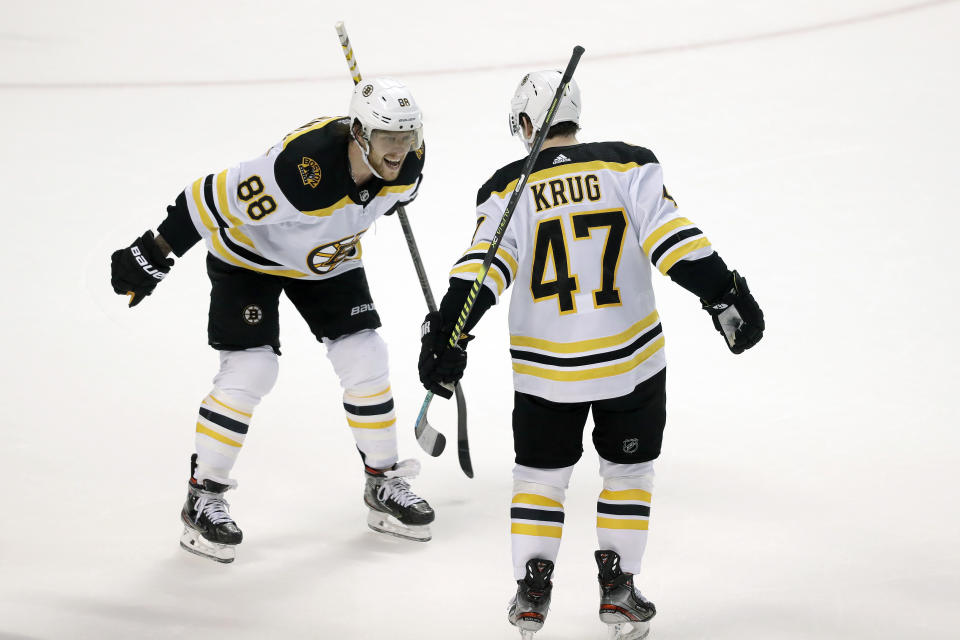 Boston Bruins right wing David Pastrnak (88) celebrates with defenseman Torey Krug (47) after Krug scored the winning goal during an overtime period of an NHL hockey game against the Florida Panthers, Thursday, March 5, 2020, in Sunrise, Fla. (AP Photo/Wilfredo Lee)