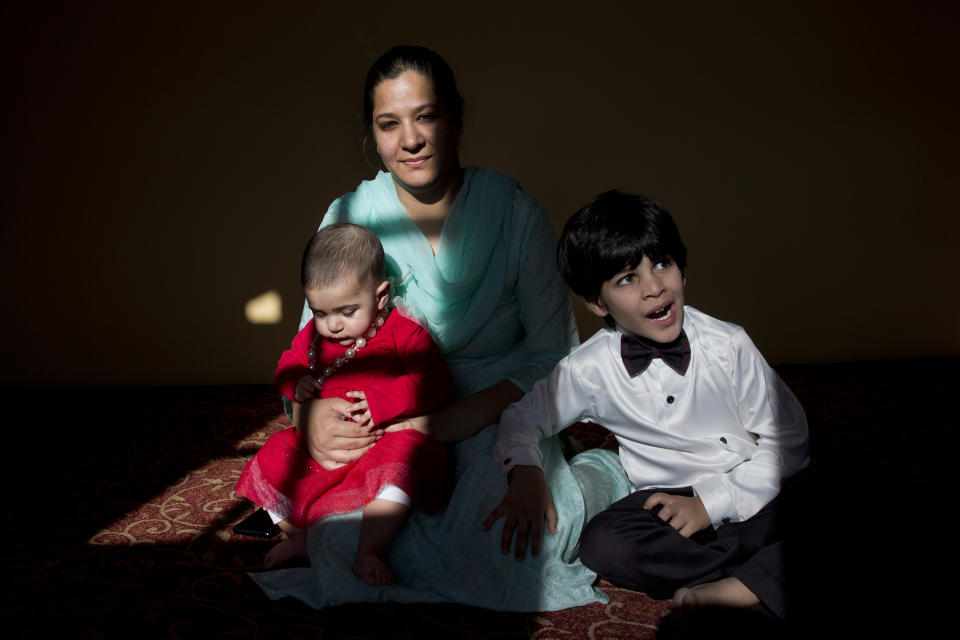 In this Oct. 14, 2019, photo, a Kashmiri-born Australian Sumaya Rather sits with her eight-month-old daughter Noor Rather and four-year-old son Ahmed Rather inside her maternal home on the outskirts of Srinagar, Indian controlled Kashmir. Sumaya said Noor fell ill because she couldn’t adjust to the milk supplement brands that were available in Srinagar. Taking her to a hospital was a big challenge as there were protests and road blockades set up by both soldiers and Kashmiri youths. (AP Photo/ Dar Yasin)