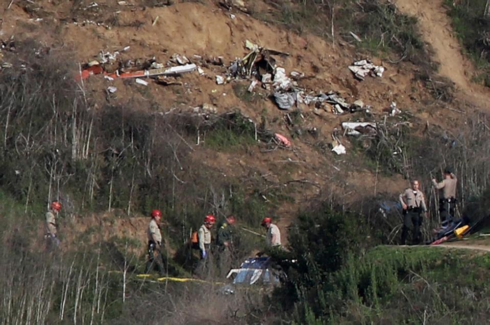 Sherriffs and officials investigate the helicopter crash site of NBA star Kobe Bryant in Calabasas, California (REUTERS)