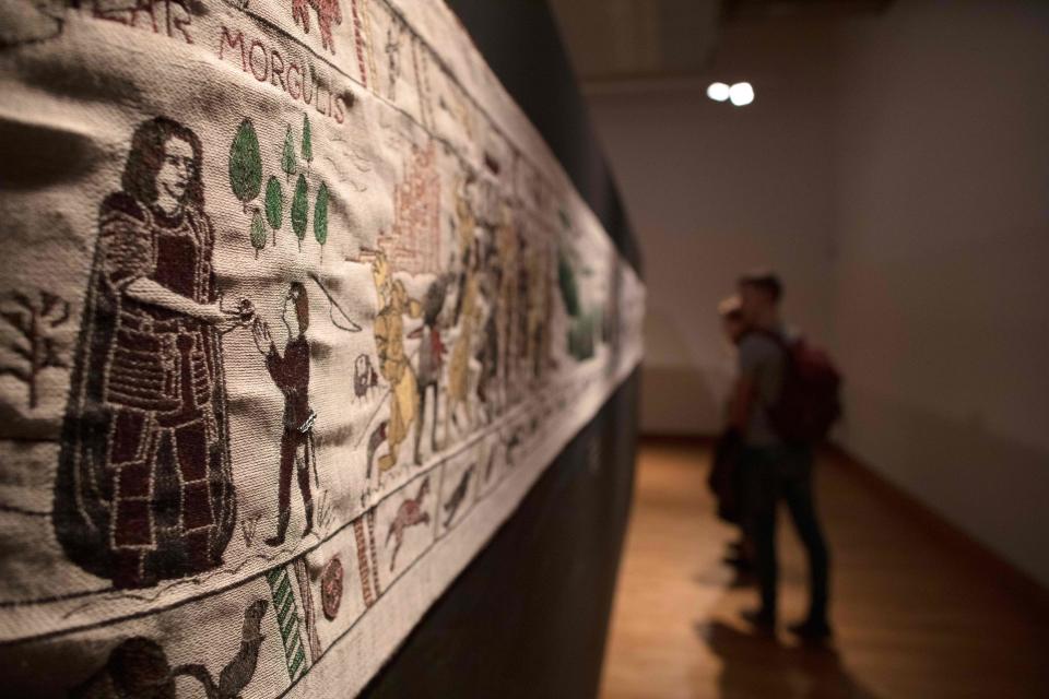 Members of the public look at completed sections of a tapestry depicting the hit television series Game of Thrones at the Ulster Museum in Belfast on July 5, 2019. - Like the Bayeux Tapestry, the Game of Thrones Tapestry is woven of fine linen and hand-embroidered, with decorative borders and a central pictorial narrative. It will reach 90m by the end of the final season of the show. (Photo by Paul Faith / AFP)        (Photo credit should read PAUL FAITH/AFP/Getty Images)