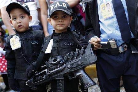 Children dressed as police officers parade during the Carnival festival in Caracas March 4, 2014. REUTERS/Carlos Garcia Rawlins