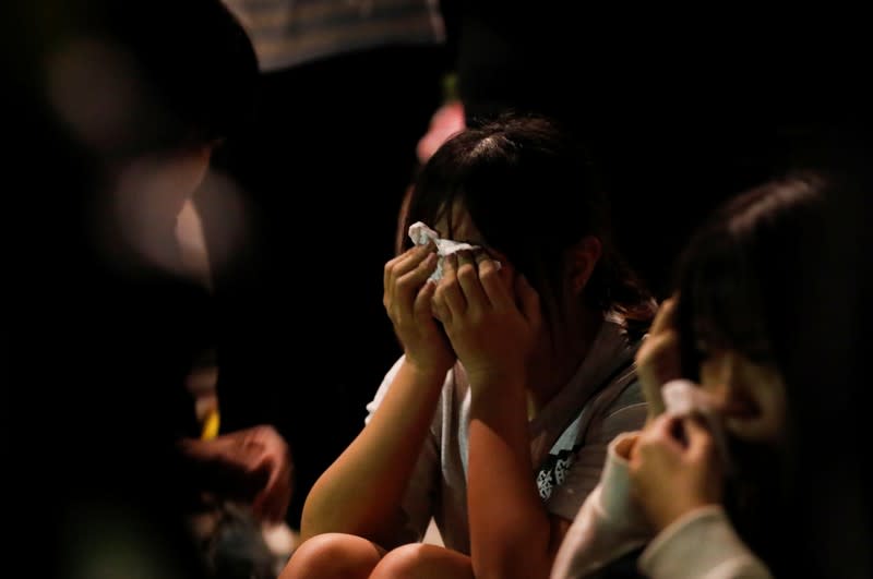 An anti-government demonstrator cries after surrendering at the campus of the Hong Kong Polytechnic University (PolyU), in Hong Kong