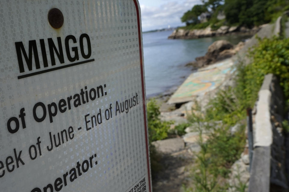 An advisory lists the name Mingo on a sign at an entrance to Mingo Beach, in Beverly, Mass., Wednesday, June 15, 2022. The beach was named after enslaved African American Robin Mingo, who according to legend, was promised his freedom if the tide ever receded enough for him to walk out onto a rocky ledge offshore that becomes exposed at low tide. Students and faculty at Endicott College in Beverly are researching the local legend and proposing ways to memorialize Mingo. (AP Photo/Steven Senne)