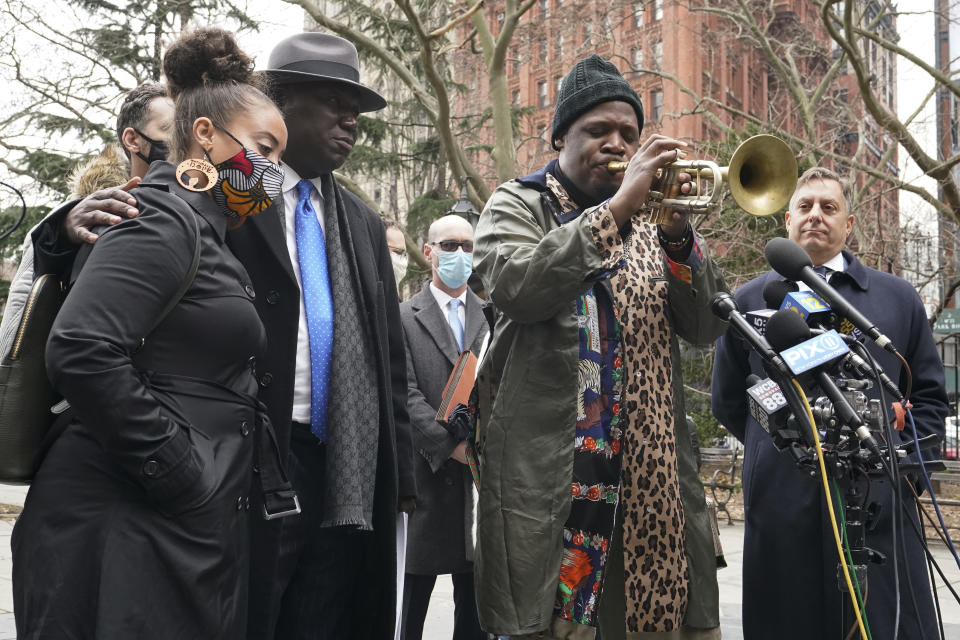 Katty Rodriguez, left, attorneys Ben Crump, second from left, and Paul Napoli, right listen to Keyon Harrold Sr. play his saxophone during a news conference to announce the filing of a lawsuit against Arlo Hotels and Miya Ponsetto, Wednesday, March 24, 2021, in New York. Keyon Harrold and his son were allegedly racially profiled in an Arlo hotel in Manhattan by Miya Ponsetto in December 2020. Ponsetto wrongly accused Keyon Harrold Jr. of stealing her phone and physically attacking him. (AP Photo/Mary Altaffer)