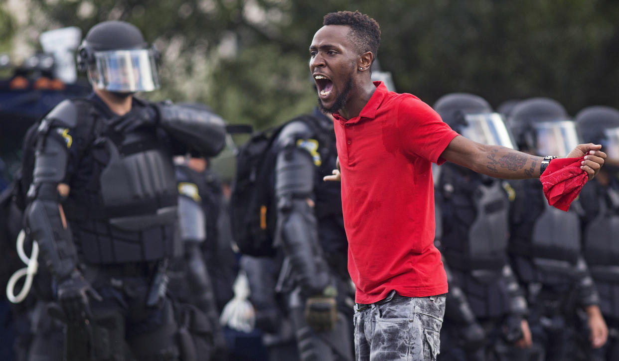 A protester yells at police in front of the Baton Rouge Police Department headquarters after police arrived in riot gear to clear protesters from the street in Baton Rouge, La., Saturday, July 9, 2016. Several protesters were arrested. (AP Photo/Max Becherer)