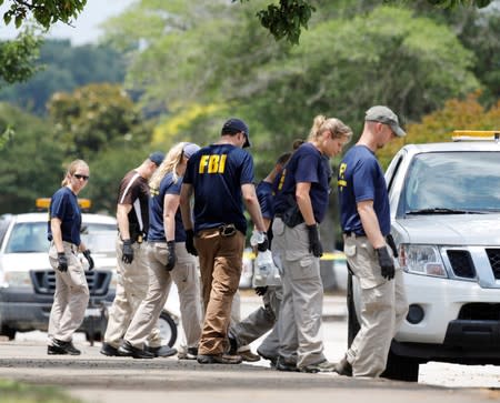 Federal Bureau of Investigation (FBI) Evidence Response Team members search a parking lot outside a municipal government building where a shooting incident occurred in Virginia Beach