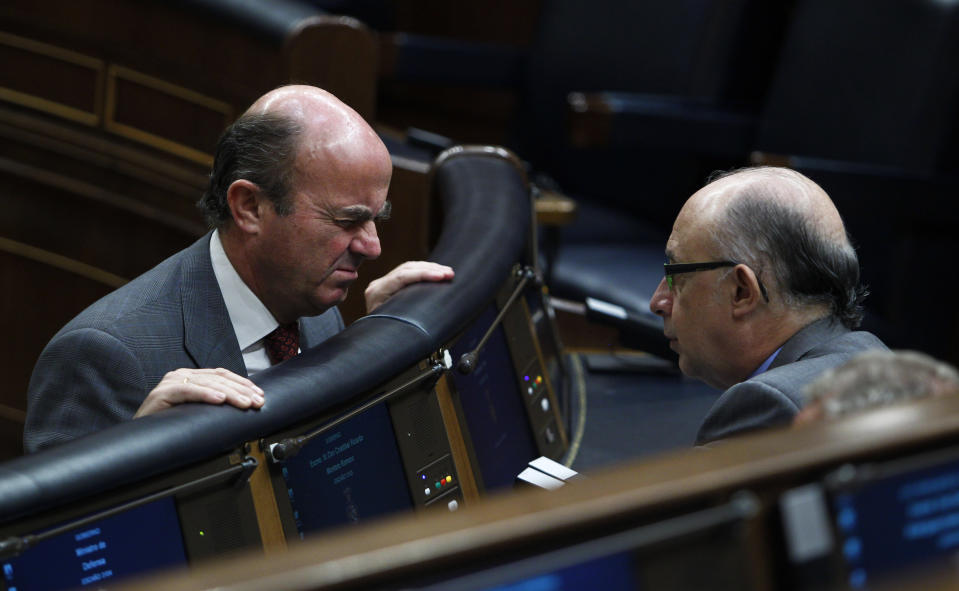 Spain's Minister of Economy and Competitiveness Luis de Guindos, left, and the Minister for the Treasury and Public Administration Services Cristobal Montoro speak during a session at the Spanish Parliament, in Madrid, Spain, Wednesday, July 18, 2012. (AP Photo/Andres Kudacki)