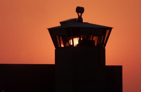 FILE PHOTO: The sun sets behind one of the guard towers at the Federal Penitentiary in Terre Haute, Indiana, June 10, 2001. REUTERS/Andy Clark/File Photo