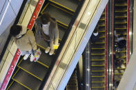 People wearing protective masks to help curb the spread of the coronavirus take usually crowded escalators at a shopping arcade in Tokyo Saturday, Jan. 9, 2021. The Japanese capital confirmed more than 2200 new coronavirus cases on Saturday. Japanese Prime Minister Yoshihide Suga declared a state of emergency last Thursday for Tokyo and three other prefectures to ramp up defenses against the spread of the coronavirus. (AP Photo/Eugene Hoshiko)