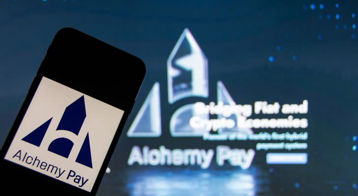 An iPhone with the Alchemy Pay (ACH) logo on the screen.