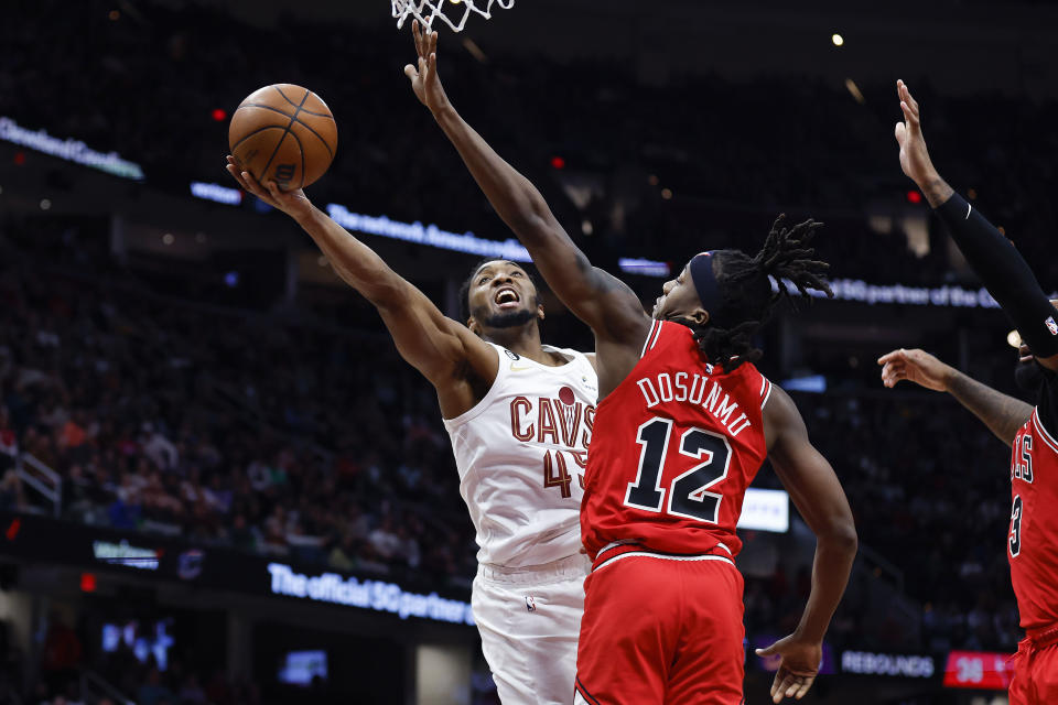 Cleveland Cavaliers guard Donovan Mitchell (45) shoots against Chicago Bulls guard Ayo Dosunmu (12) during the second half of an NBA basketball game, Saturday, Feb. 11, 2023, in Cleveland. (AP Photo/Ron Schwane)