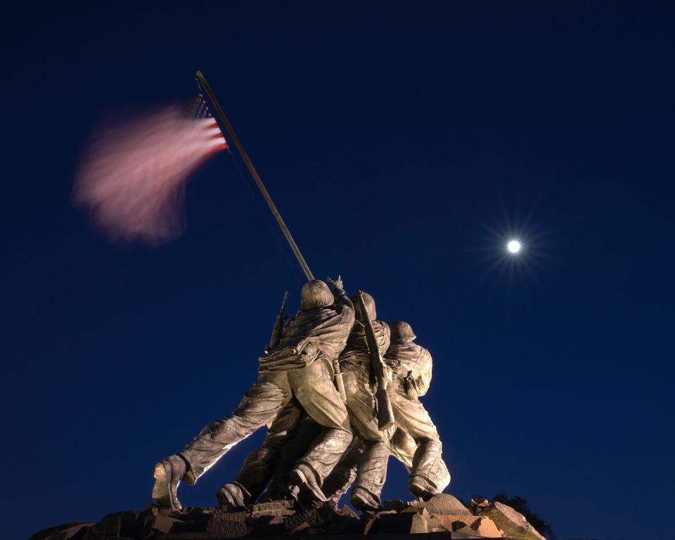 A long exposure photo of the U.S. Marine Corps War Memorial, Arlington, Virginia. Depicting the flag raising on Mt. Suribachi, Iwo Jima, the sculpture is one of the largest in the world with thirty-two-foot-tall figures. A long exposure was used to show “the broad stripes and bright stars … gallantly streaming.” “Uncommon valor was a common virtue” is emblazoned on the base of the memorial.