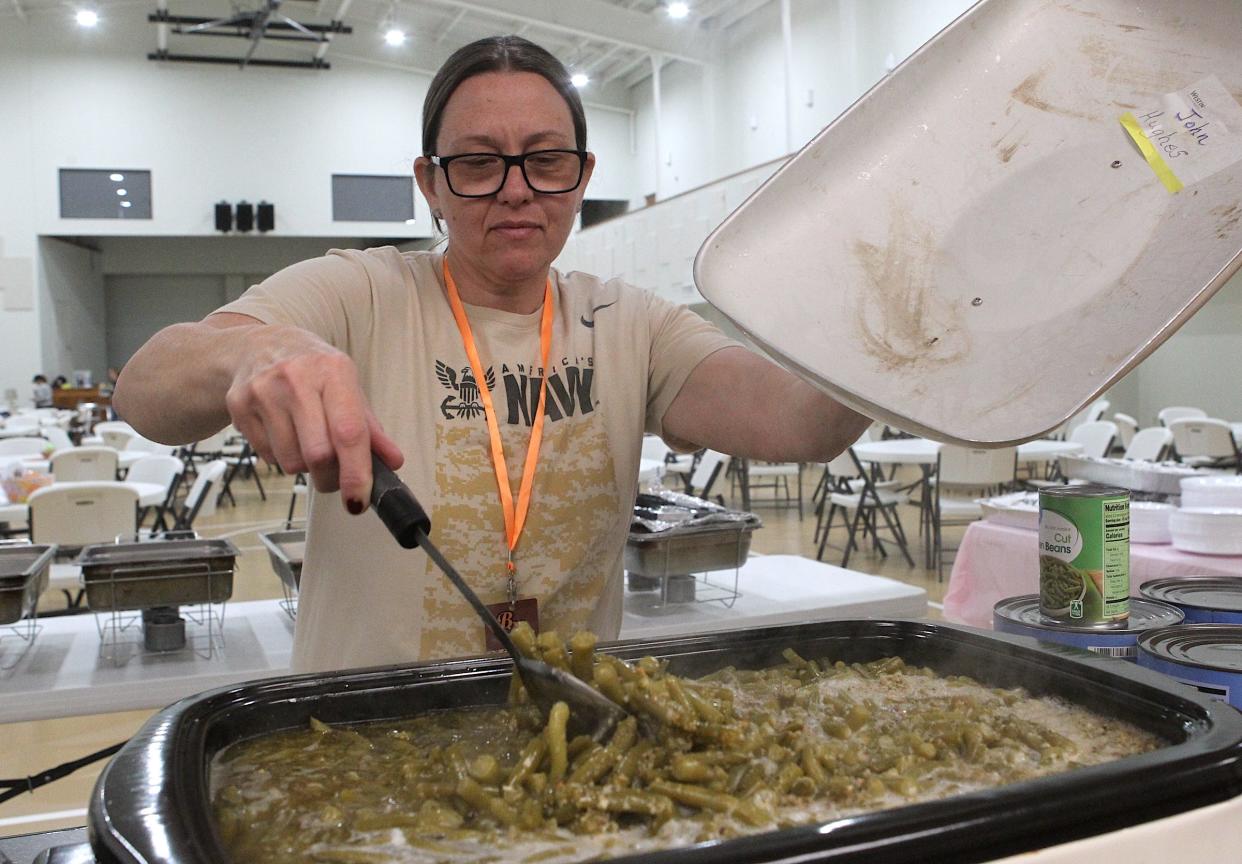 Volunteer Ariana Wilson stirs green beans in preparation for the annual Berth's Mission Free Community Easter Meal Saturday. The event was held at both the Bedford First Baptist Church, and the Mitchell Tulip Street Christian Church from 2-5 p.m. There was also free clothing available in a side room at the First Baptist Church for those who needed it. Anyone wanting to donate to Bertha's Mission can check out their Facebook page.