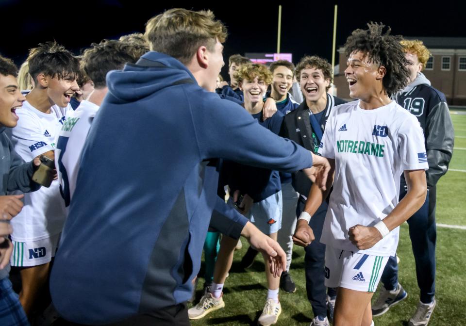 Peoria Note Dame's Kayden Hudson (7) celebrates with fans and teammates after PND's 1-0 victory over Marmion Academy in the Class 2A soccer supersectionals Tuesday, Nov. 1, 2022 at Sterling High School in Sterling. Hudson scored the game-winner on a header over the Marmion goalkeeper late in the match.