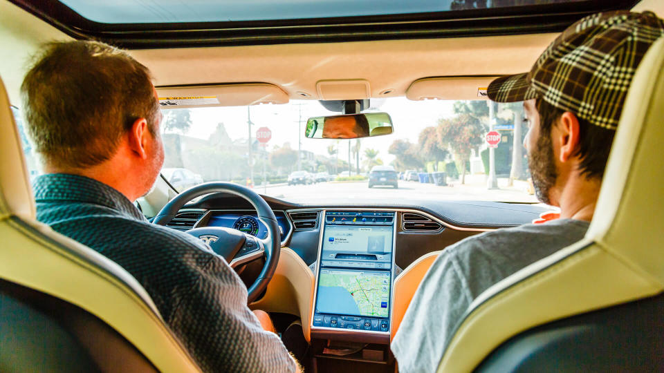 Los Angeles, United States - May 17, 2013: Men driving in electric car Tesla Model S on street of Santa Barbara in Los Angeles, California, USA.