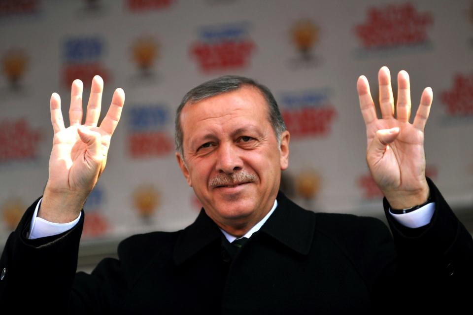 Turkish Prime Minister Recep Tayyip Erdogan waves the four finger sign of rabia during a rally of the Justice and Development Party in the Kartal district at the asia side of Istanbul on March 29, 2014.