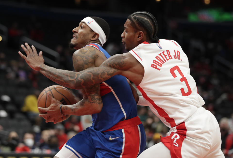 Washington Wizards' Bradley Beal moves the ball as Houston Rockets' Kevin Porter Jr. (3) defends during the first half of an NBA basketball game Wednesday, Jan. 5, 2022, in Washington. (AP Photo/Luis M. Alvarez)