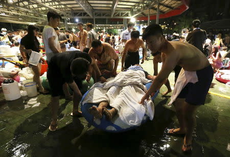 People carry an injured victim from an accidental explosion during a music concert at the Formosa Water Park in New Taipei City, Taiwan, June 27, 2015. REUTERS/Wu Chia