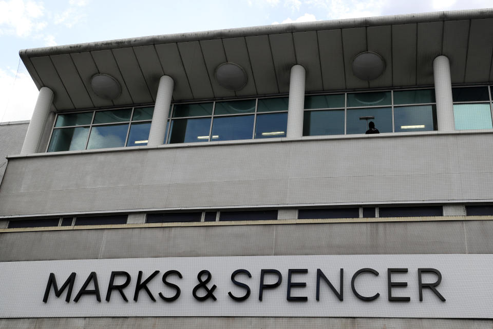 A window cleaner works above a branch of Marks and Spencer in London, Tuesday, Aug. 18, 2020. Marks and Spencer has said it will cut 7,000 jobs over the next three months as the UK retailer overhauls its business in the latest sign of how the coronavirus pandemic has disrupted the high street. (AP Photo/Kirsty Wigglesworth)