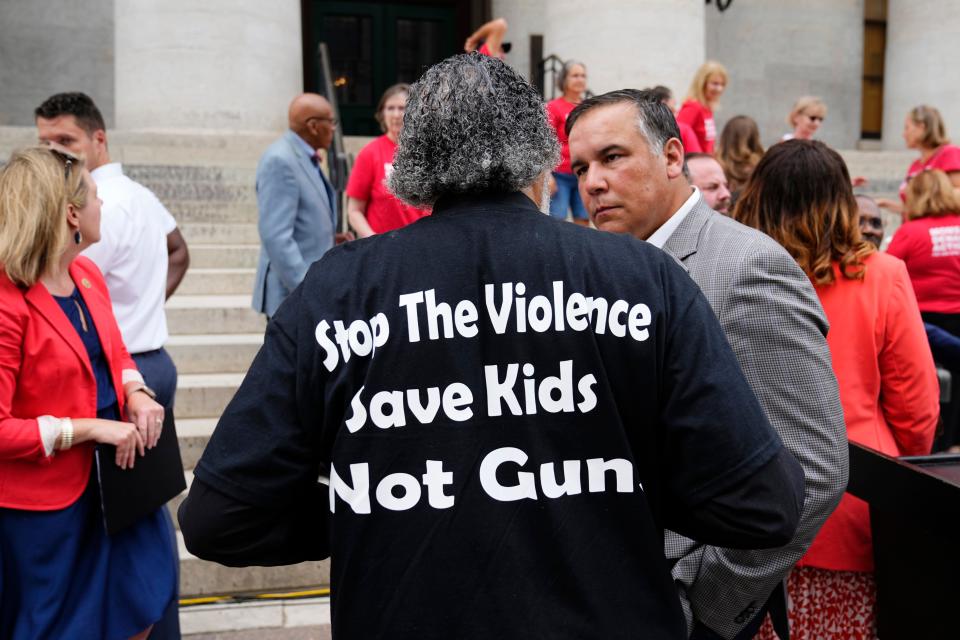 Pastor Kujenga Ashe talks to Columbus mayor Andrew Ginther following a press conference with city and state officials demanding gun control reforms on the steps of the Ohio Statehouse.