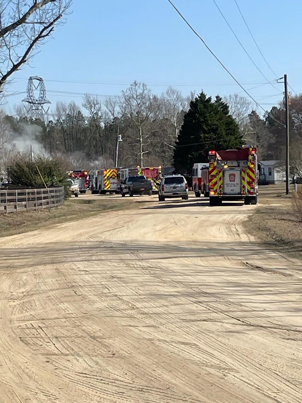 Emergency vehicles park near the scene of a deadly house fire in Grays Creek on Monday, Feb. 26, 2024. Three people were killed. The cause is under investigation.