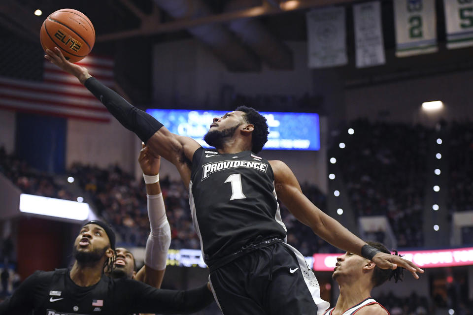 Providence's Al Durham makes a basket past Connecticut's Andre Jackson, bottom right, in the second half of an NCAA college basketball game, Saturday, Dec. 18, 2021, in Hartford, Conn. (AP Photo/Jessica Hill)