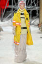 <p>A model wears a yellow safety coat with orange reflective paneling, a balaclava, a striped sweater, gloves, and a prairie skirt at the Calvin Klein fall 2018 show. (Photo: Getty Images) </p>