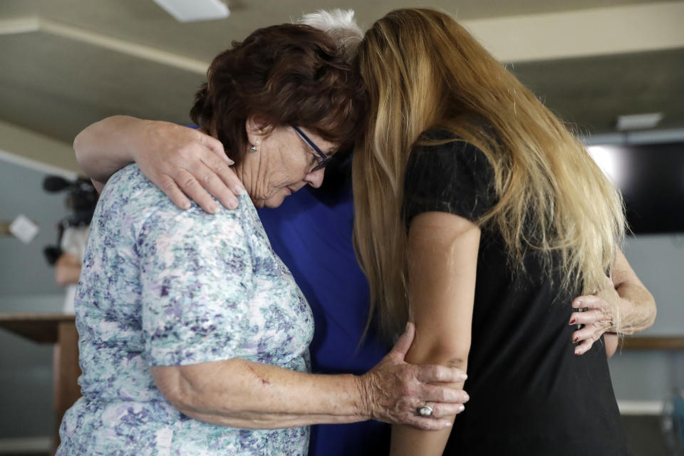 Alexandria Johnson, at right, whose home was damaged by an earthquake, prays with fellow congregants including Sara Smith, left, in the aftermath of an earthquake at the Christian Fellowship of Trona Sunday, July 7, 2019, in Trona, Calif. (AP Photo/Marcio Jose Sanchez)