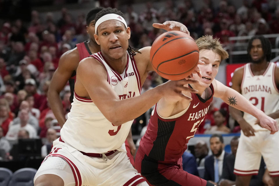Indiana forward Malik Reneau, left, chases the ball with Harvard center Matt Filipowski, front right, in the second half of an NCAA college basketball game in Indianapolis, Sunday, Nov. 26, 2023. (AP Photo/AJ Mast)