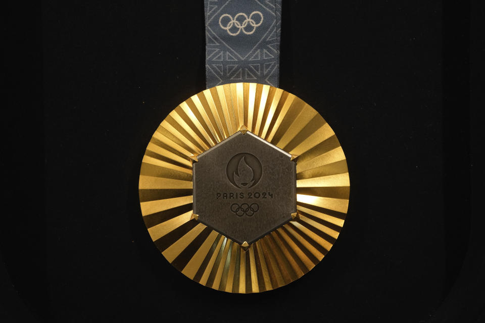 The Paris 2024 Olympic gold medal is presented to the press, in Paris, Thursday, Feb. 1, 2024. A hexagonal, polished piece of iron taken from the Eiffel Tower is being embedded in each gold, silver and bronze medal that will be hung around athletes' necks at the July 26-Aug. 11 Paris Games and Paralympics that follow. (AP Photo/Thibault Camus)