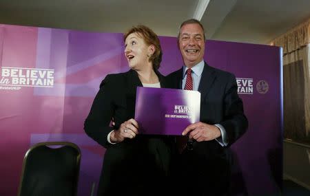 Britain's United Kingdom Independence Party (UKIP) leader Nigel Farage and Deputy Chairman Suzanne Evans pose with a copy of their party's manifesto in Aveley, southeast England April 15, 2015. REUTERS/Cathal McNaughton