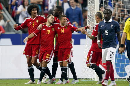 Belgium's players Marouane Fellaini (L), Eden Hazard (2nd L) and Dries Mertens (4th L) react after scoring the fourth goal against France during their international friendly soccer match at the Stade de France, in Saint-Denis, near Paris, France, June 7, 2015. REUTERS/Charles Platiau