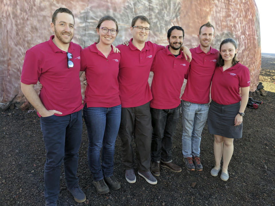 In this photo provided by the University of Hawaii, scientists Joshua Ehrlich, from left, Laura Lark, Sam Payler, Brian Ramos, Jay Bevington and Ansley Barnard, pose for a photo before they enter a geodesic dome called Hawaii Space Exploration Analog and Simulation, or HI-SEAS located 8,200 feet above sea level on Mauna Loa on the island of Hawaii, Thursday, Jan. 19, 2017. The four men and two women moved into their new simulated space home Thursday afternoon, as part of a human-behavior study that could help NASA as it draws up plans for sending astronauts on long missions to Mars. (University of Hawaii via AP)