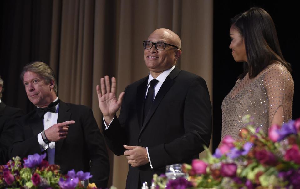 FILE - In this Saturday, April 30, 2016 file photo, comedian Larry Wilmore, center, waves as he is introduced at the annual White House Correspondents' Association dinner in Washington. Wilmore's performance at the event ended with, "Yo Barry, you did it, my n---a" _ an "N word" reference that upset many. Obama’s press secretary says afterward that the president "appreciated the spirit" of the remark. (AP Photo/Susan Walsh)