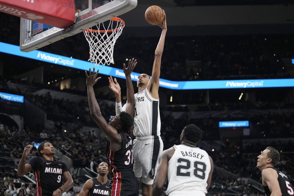 San Antonio Spurs center Victor Wembanyama (1) scores over Miami Heat center Thomas Bryant (31) during the second half of a preseason NBA basketball game in San Antonio, Friday, Oct. 13, 2023. (AP Photo/Eric Gay)