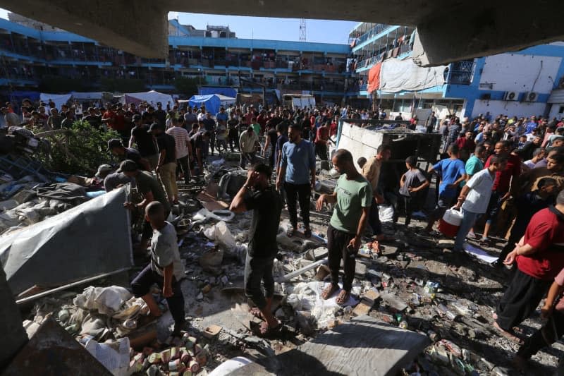 Palestinians stand in the courtyard of a school after an Israeli attack at the school of United Nations Relief and Works Agency for Palestine Refugees in the Near East (UNRWA) at Nuseirat Refugee Camp. Omar Ashtawy/APA Images via ZUMA Press Wire/dpa