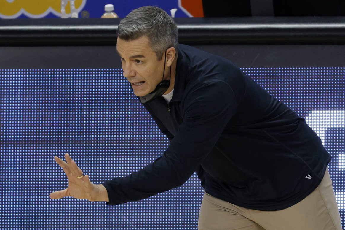 Tony Bennett of the Virginia Cavaliers courtside holding his left hand out