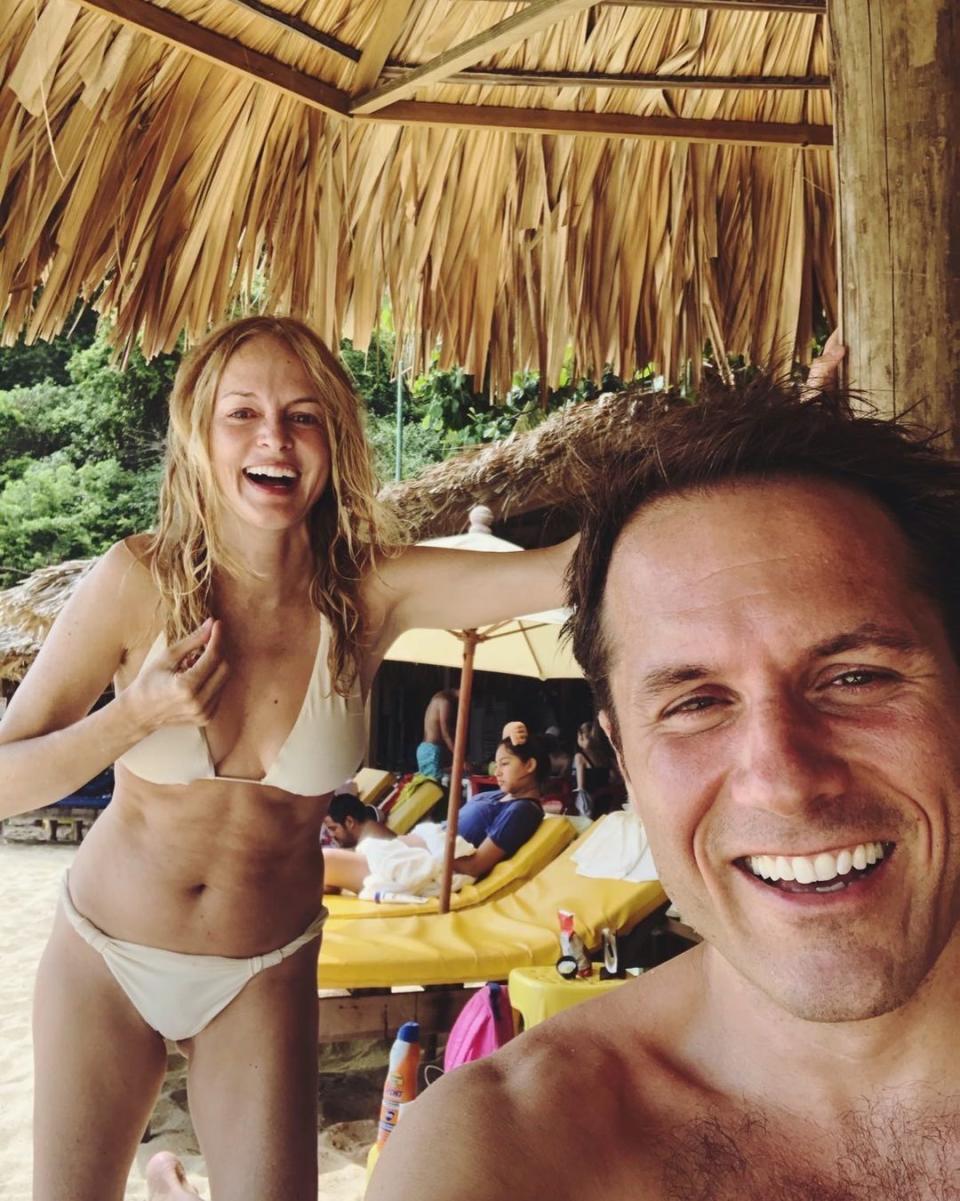 Heather Graham with a friend in a white bikini on a beach