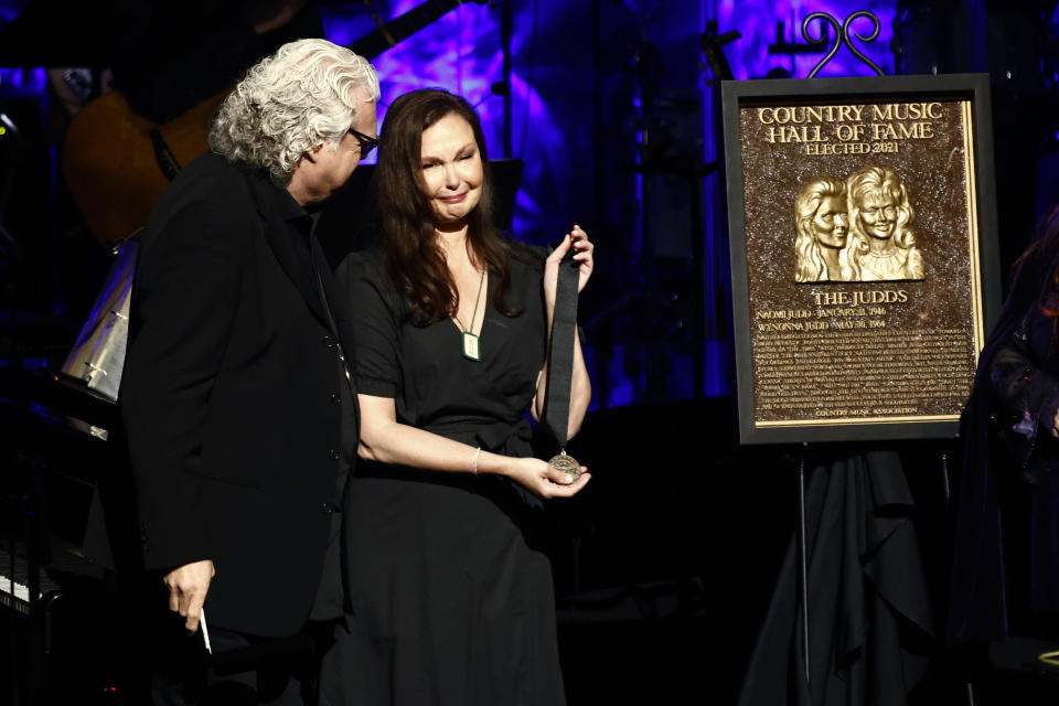 Ricky Skaggs presents Ashley Judd the medallion that would have been given to her mother Naomi Judd, who died unexpectedly a day earlier, during the Medallion Ceremony at the Country Music Hall of Fame on Sunday, May 1, 2022, in Nashville, Tenn. (Photo by Wade Payne/Invision/AP)