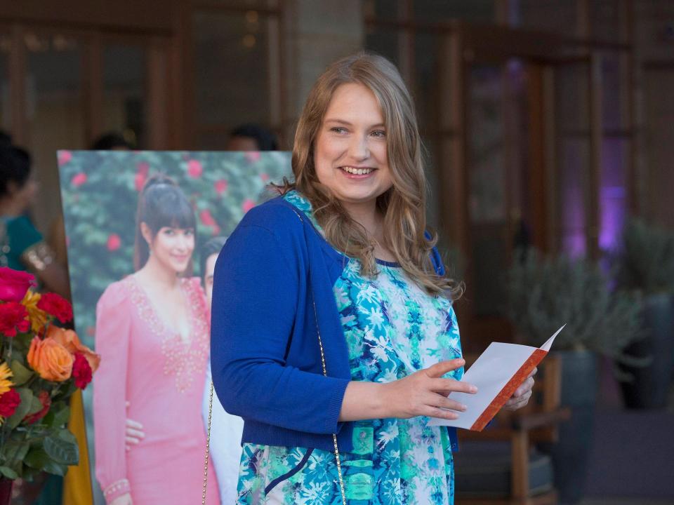 Merritt Wever wears a blue dress and dark blue cardigan on the set of "New Girl"