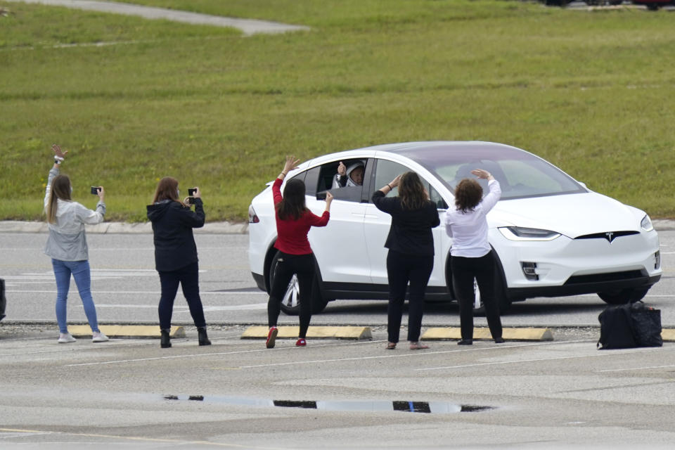 Astronaut Doug Hurley waves out the window as he and astronaut Bob Behnken ride out to the SpaceX Falcon 9, with the Crew Dragon spacecraft on top of the rocket, on Launch Pad 39-A, Wednesday, May 27, 2020, at Kennedy Space Center in Cape Canaveral, Fla. Two astronauts will fly on the SpaceX Demo-2 mission to the International Space Station scheduled for launch Wednesday afternoon. (AP Photo/David J. Phillip)