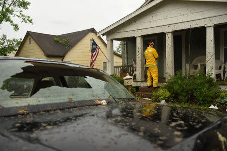 A member of the Jefferson City Fire Department checks houses for people on Woodland Avenue following a tornado touchdown overnight in Jefferson City, Missouri, U.S. May 23, 2019. REUTERS/Antranik Tavitian