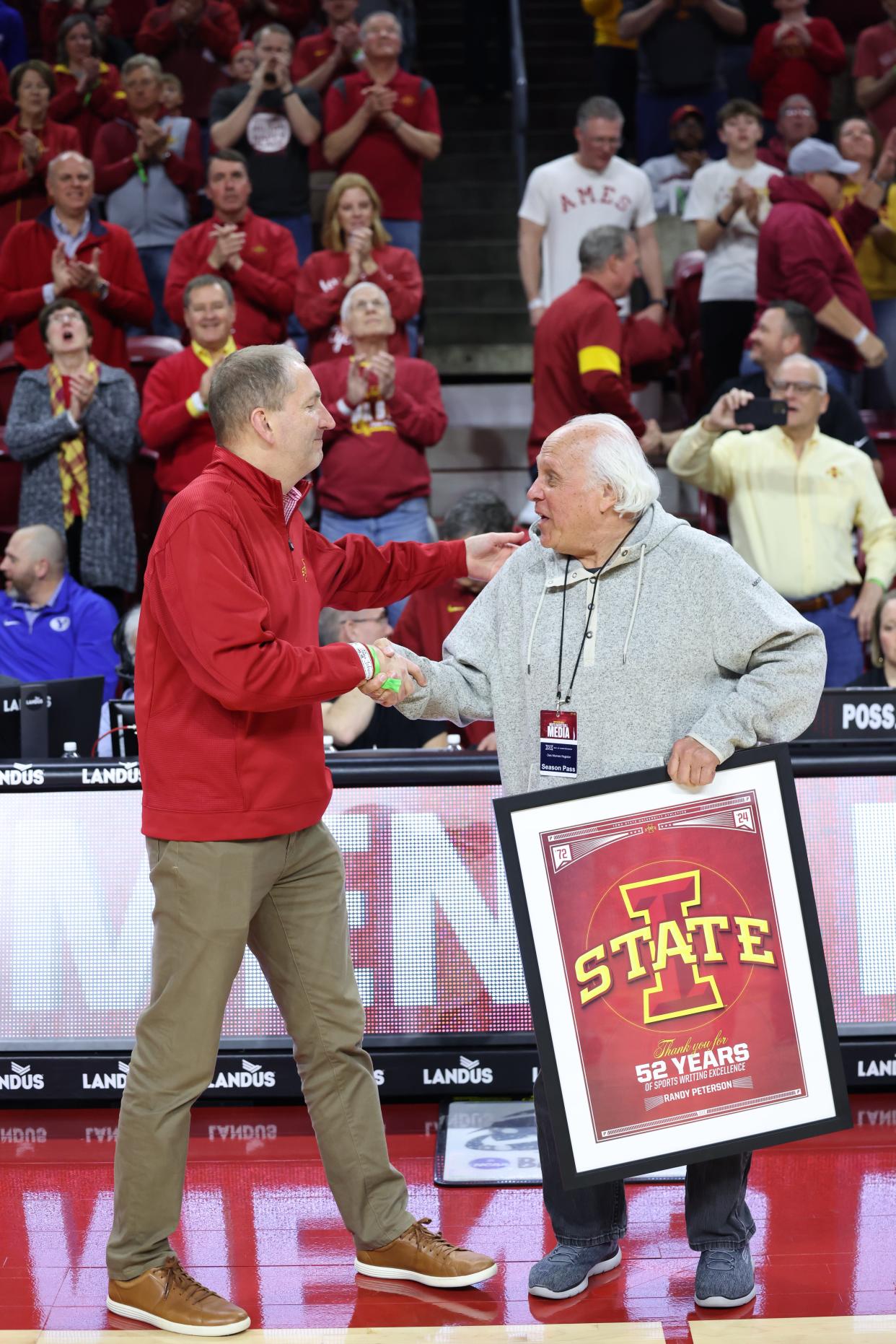 Des Moines Register sports columnist Randy Peterson, right, is greeted by Iowa State athletics director Jamie Pollard before the March 6, 2024, men's basketball game vs. BYU at Hilton Coliseum in Ames. Iowa State honored Peterson for his 52-year career at the Register. Peterson is retiring this year.