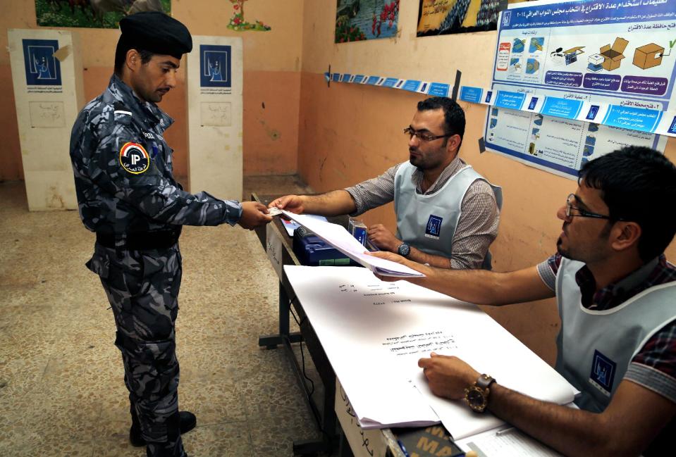 An Iraqi federal policeman prepares to cast his vote at a polling center in Basra, Iraq's second-largest city, 340 miles (550 kilometers) southeast of Baghdad, Iraq, Monday, April 28, 2014. Iraqi officials say suicide bombers have targeted polling centers as soldiers and security forces cast ballots ahead of parliamentary elections. (AP Photo/ Nabil al-Jurani)