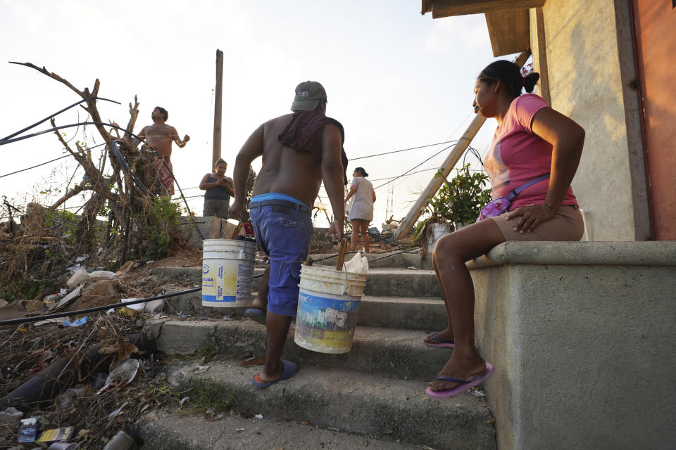 Parientes de Fautino Bonilla y Mariel Campos trabajan para retirar los escombros de su casa familiar cerca de tres semanas después del paso del huracán Otis de categoría 5 en el área de Alta Cuauhtémoc de Acapulco, México, el jueves 9 de noviembre de 2023. (AP Foto/Marco Ugarte)