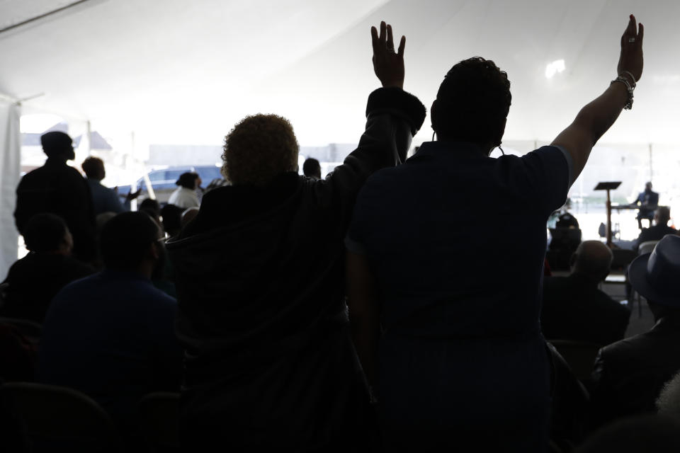 Worshippers pray during a service in a tent at Mount Bethel Missionary Baptist Church, Sunday, March 8, 2020, in Nashville, Tenn. The congregation held their Sunday service in a tent in the parking lot near the church facilities, which were heavily damaged by a tornado March 3. (AP Photo/Mark Humphrey)