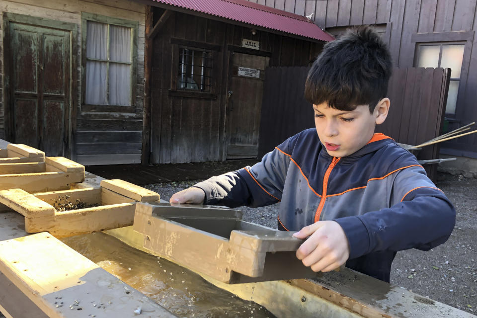 A young boy is seen "panning for silver" in Tombstone, Ariz., on Saturday, Nov. 30, 2019. Tombstone is famous for an 1881 gun battle that left three dead, a confrontation that has been the inspiration for numerous books and movies. The town was founded and flourished in the late 19th century after large amounts of silver were found in the area. (AP Photo/Peter Prengaman)