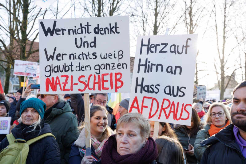 People participate in a demonstration against right-wing extremism holding posters reading  "Heart up, brain in, hate out, AFD out". Friso Gentsch/dpa