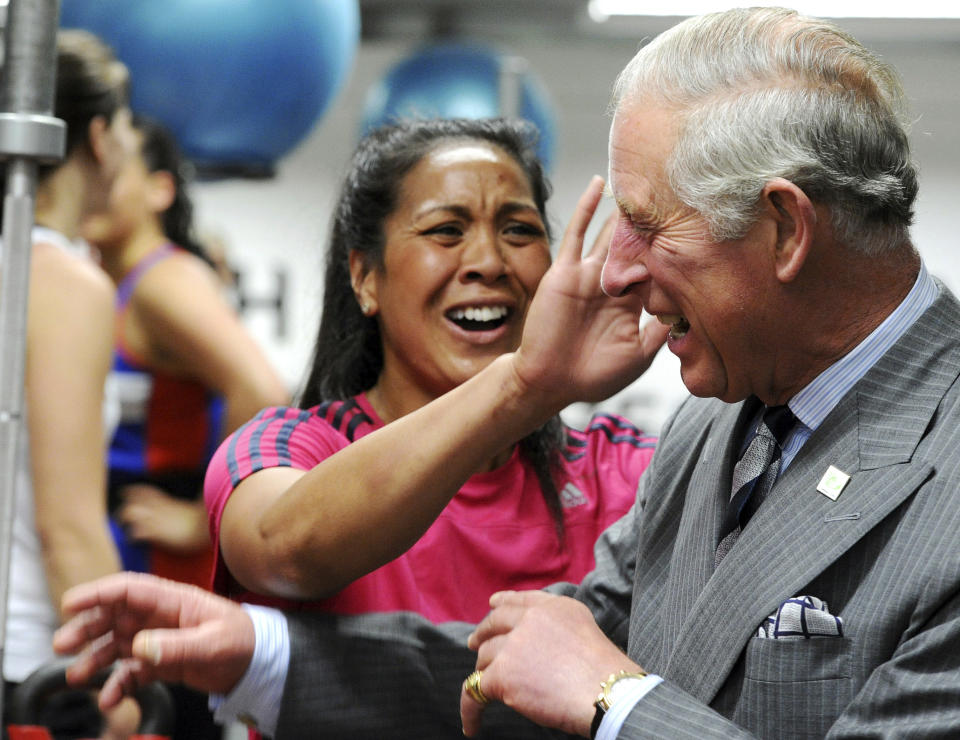 Britain's Prince Charles has sweat wiped from his face after receiving a hug from one of the members of the New Zealand women's sevens rugby team at the AUT Millennium, New Zealand's national training center for high performance sports, in Auckland, New Zealand, Monday, Nov. 12, 2012. (AP Photo/SNPA, Ross Setford)