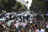 Hundreds of taxi drivers gather round the Angel of Independence monument to protest ride apps, in Mexico City, Monday, Oct. 7, 2019. The protesters want the apps banned, arguing that the apps are unfair competition because those drivers are more loosely regulated and don't have to pay licensing fees. (AP Photo/Marco Ugarte)